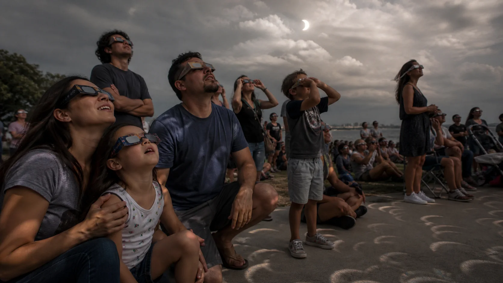 Famille observant une éclipse solaire avec des lunettes certifiées
