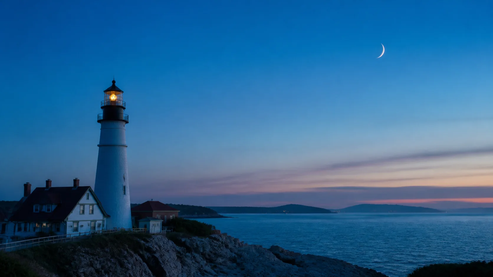 Croissant lunaire photographié avec un phare et la mer au crépuscule